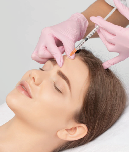Profissional de estética usando luvas e seringa para aplicar toxina botulínica na região da testa de uma paciente em clínica em Curitiba.