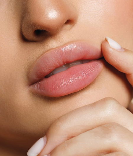 Close dos lábios volumosos, hidratados e definidos de uma mulher com maquiagem suave, destacando o resultado natural do preenchimento labial em Curitiba.